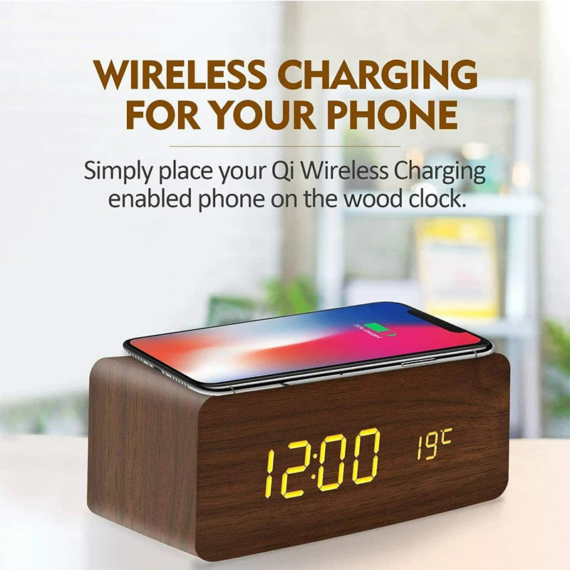 Wooden clock with wireless charging pad for phone on a blurred indoor background